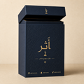 علبة عطر كحلية فاخرة بتذهيب ونقش بارز وحسابات التواصل مطبوعة عليها